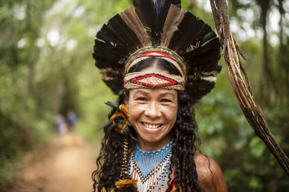 Junge indigene Frau, die einen traditionellen Kopfschmuck mit Federn trägt